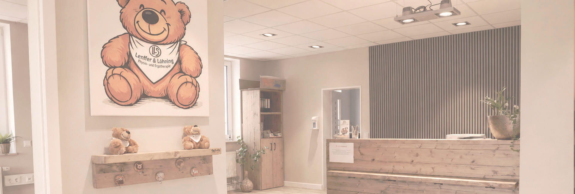 Empfangsbereich mit Holztheke, großem Teddybär-Wandbild und zwei Plüschtieren